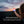 Person holding a glowing BioLite lantern against a sunset landscape