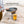 BioLite CampStove with steel grill attachment cooking a burger patty on a tabletop