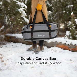 Person carrying a grey BioLite canvas bag for FirePit plus and wood in a snowy forest