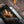 Hand using a BioLite fire poker to adjust burning wood in a portable grill