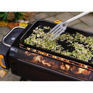 BioLite grill cooking chopped vegetables on a griddle with a metal spatula