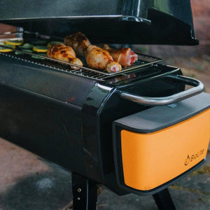 Chicken drumsticks cooking on a BioLite portable grill