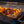 Vegetable skewers cooking on a BioLite grill grate over an open flame