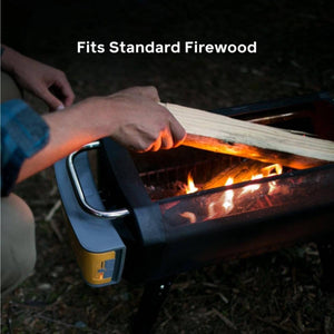 Person placing standard firewood into a BioLite fire pit