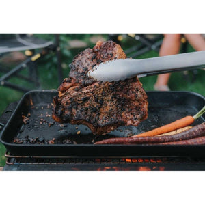 BioLite grill cooking a seared steak and carrots on a cast iron tray