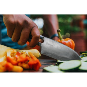 Hand holding a BioLite knife slicing vegetables on a cutting board