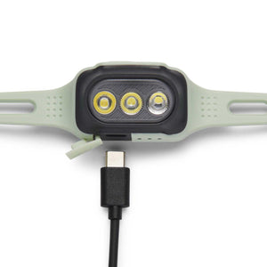 Black Diamond headlamp with three LED lights connected to a USB-C charging cable