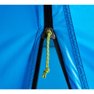 Close up of a blue tent zipper with a green cord pull