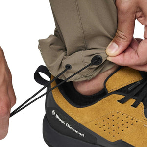 Close up of Black Diamond pants with adjustable drawstring hem over a hiking shoe