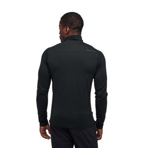 Back view of a man wearing a black long sleeve Black Diamond zip neck shirt
