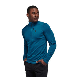 Man wearing a blue Black Diamond quarter zip long sleeve shirt