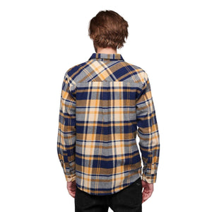Back view of a person wearing a Black Diamond blue and yellow plaid flannel shirt