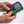 Black Diamond Recon avalanche beacon held in hands showing digital display and green switch