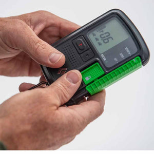Black Diamond Recon avalanche beacon held in hands showing digital display and green switch