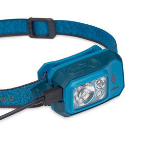Black Diamond Storm-R headlamp with blue strap and USB charging cable connected