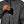 Person placing a smartphone into the chest pocket of a grey Black Diamond shell jacket