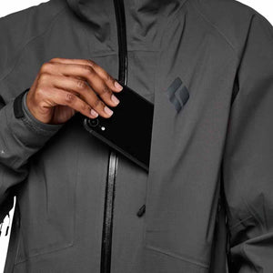 Person placing a smartphone into the chest pocket of a grey Black Diamond shell jacket