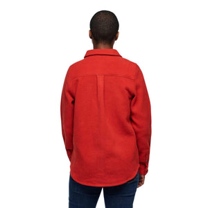 Back view of a person wearing a red long sleeve button down shirt with a collar and blue jeans