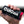 Hand holding a black Culcan Black Ice beverage insulator with a red base