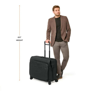 Man standing next to a black Briggs and Riley rolling garment bag with a height reference line