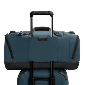Briggs and Riley blue duffel bag with a pass-through sleeve attached to a luggage handle