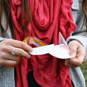 Person peeling the adhesive backing off a Hothands hand warmer packet