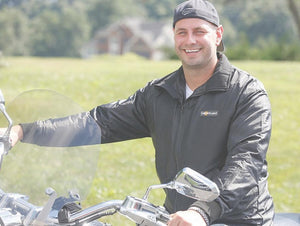 Man wearing a black California Heat jacket on a motorcycle