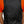 Back view of a black sleeveless vest worn over an orange shirt