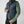 Man wearing a dark blue FjallRaven quilted vest over a green long sleeve shirt