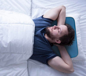 Man sleeping on a Cool Care Technologies blue cooling pillow insert