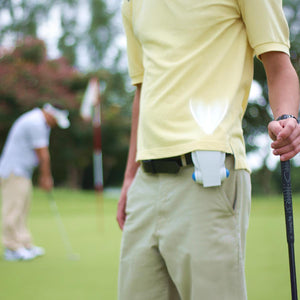 Cool On The Go personal fan clipped to a golfers waistband on a golf course