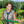 Woman wearing a grey Chill-Its cooling vest while holding a green garden hose