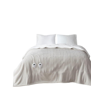Serta heated blanket with dual controllers on a bed with two white pillows