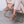 Person wearing mauve faux fur lined suede slippers while sitting in a pink velvet chair