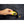 Hand placing a yellow DeWalt USB power source into a black jacket pocket