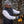 Person wearing a DeWalt black quilted vest and gloves while using a yellow power tool outdoors