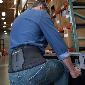 Man wearing a DonJoy back brace in a warehouse