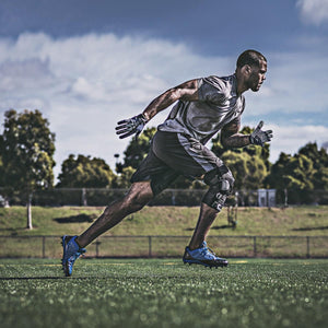 Athlete running on a field wearing a DonJoy knee brace