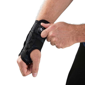Person adjusting a black wrist brace with a BOA dial closure system