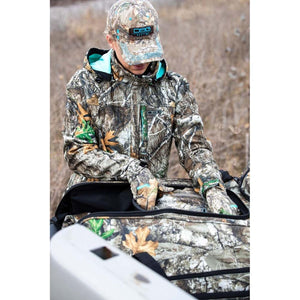 Person wearing DSG Outerwear camouflage jacket and cap packing a matching camouflage gear bag