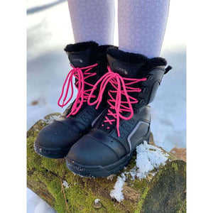 DSG Outerwear black winter boots with bright pink laces on a mossy log in the snow