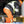 Worker in high visibility jacket and orange pants kneeling on ice while using tools