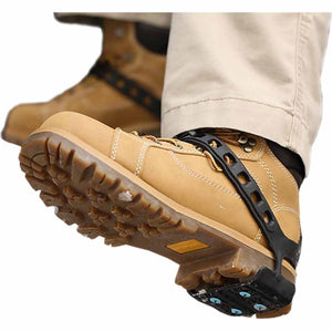 Tan work boots with black rubber ice cleats attached to the soles