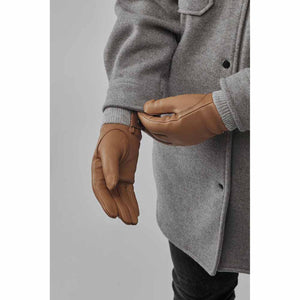 Person wearing tan Hestra leather gloves with a grey wool coat