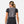 Back view of a person wearing a grey Nathan hydration vest over a black t-shirt