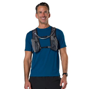 Man wearing a grey Nathan hydration vest over a blue t-shirt