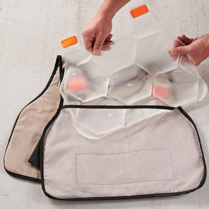 Hands inserting a Chill-Its cooling pack into a mesh vest pocket