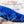 Water being poured from a bottle onto a blue cooling fabric sleeve to activate it