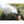 ExtremeMIST handheld nozzle spraying a fine water mist against a background of green foliage