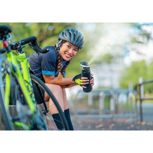 Cyclist using an ExtremeMIST water bottle to spray a cooling mist